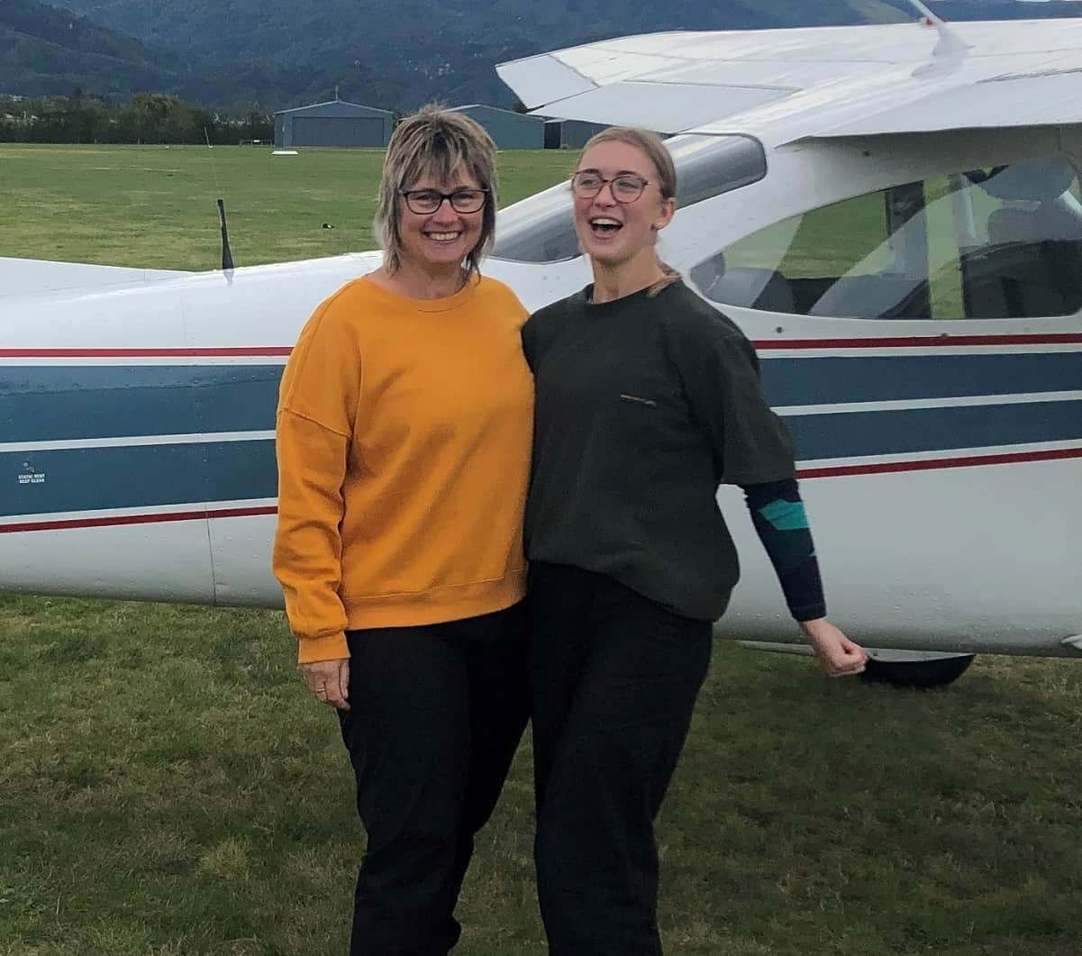 dayna standing in front of a helicopter and smiling at the camera