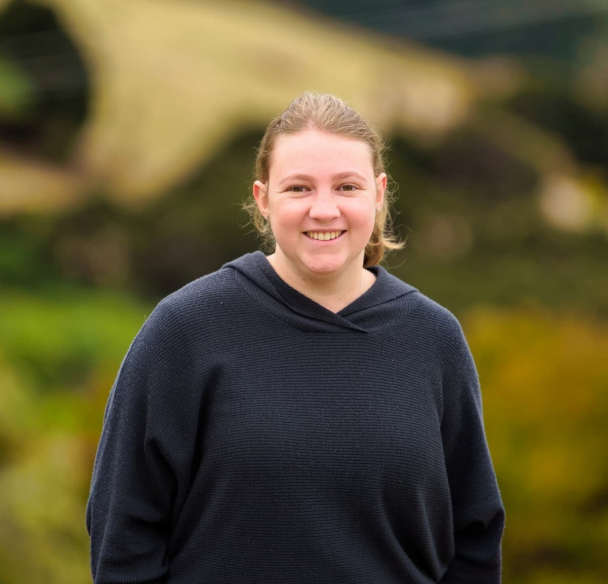 lacie wearing a black jumper and smiling at the camera