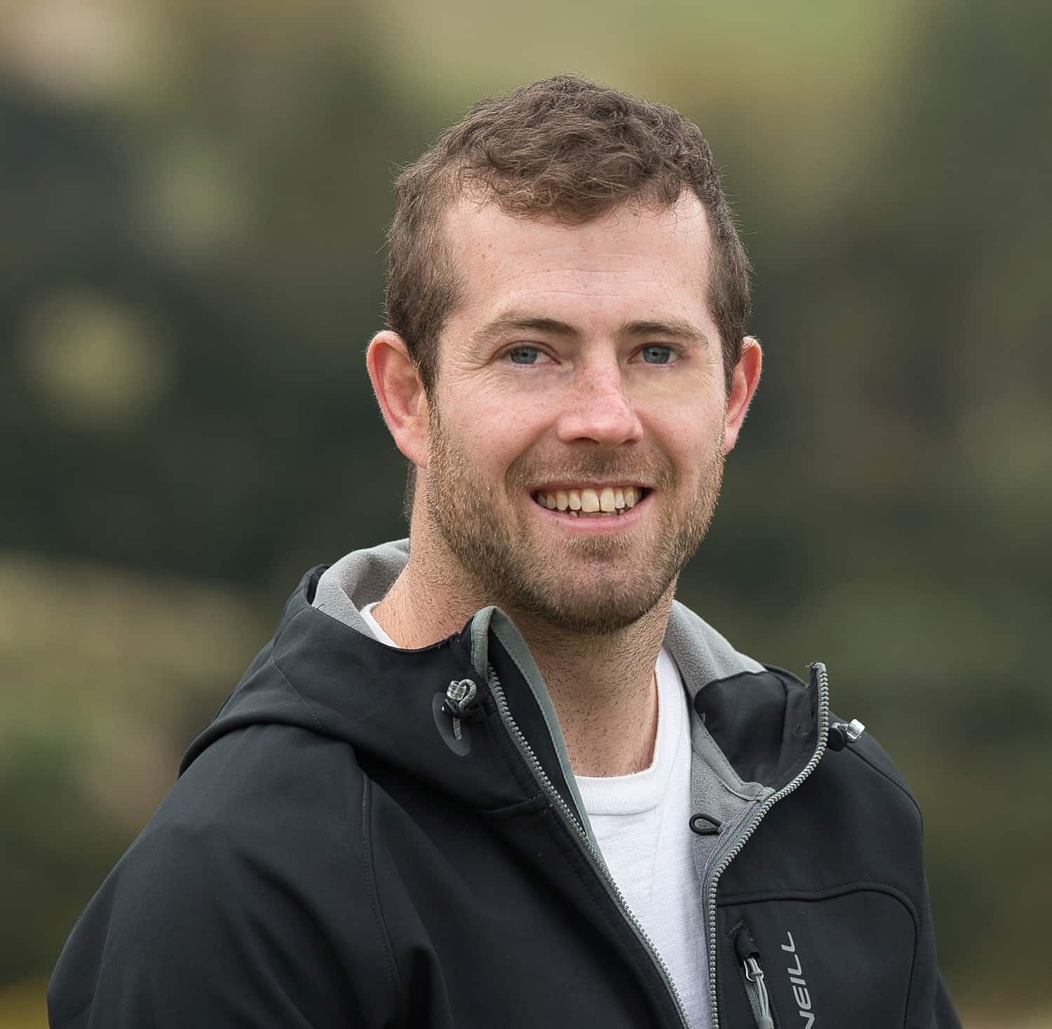 mike wearing a black jacket and smiling at the camera