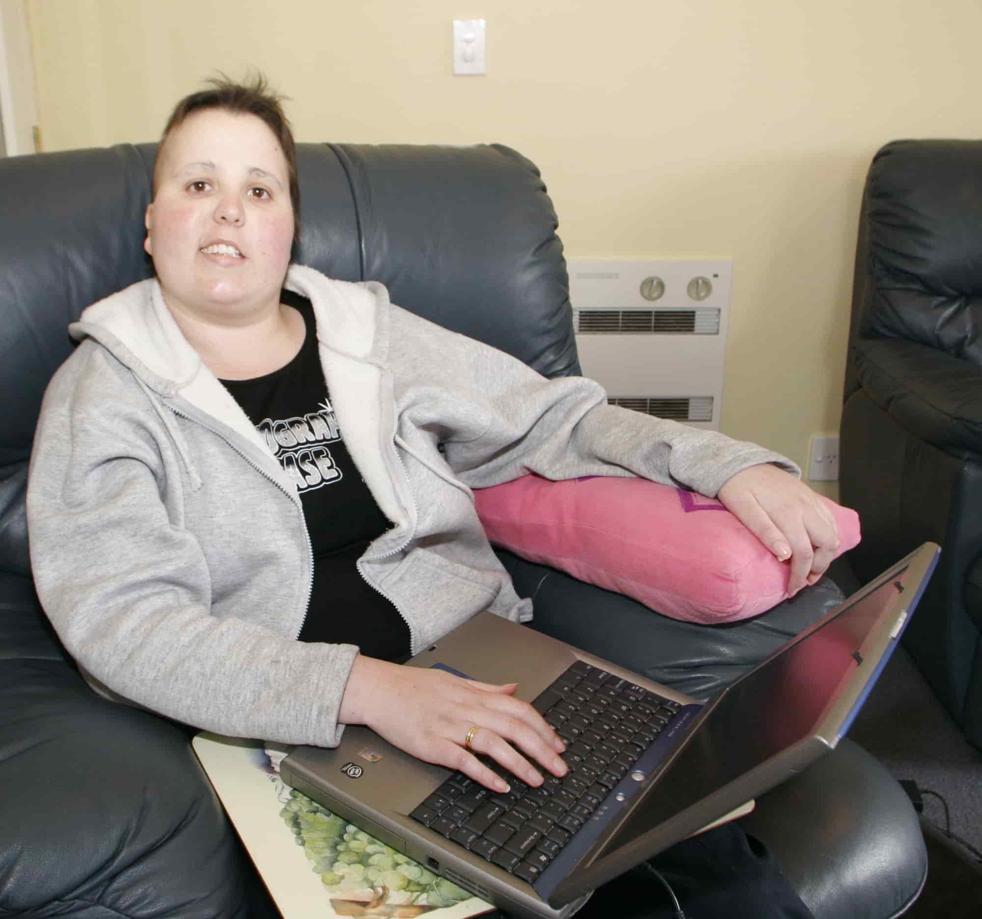 trudi sitting on a couch and using a laptop