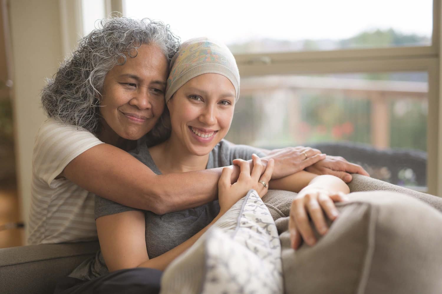 young person with cancer is being hugged by her parent