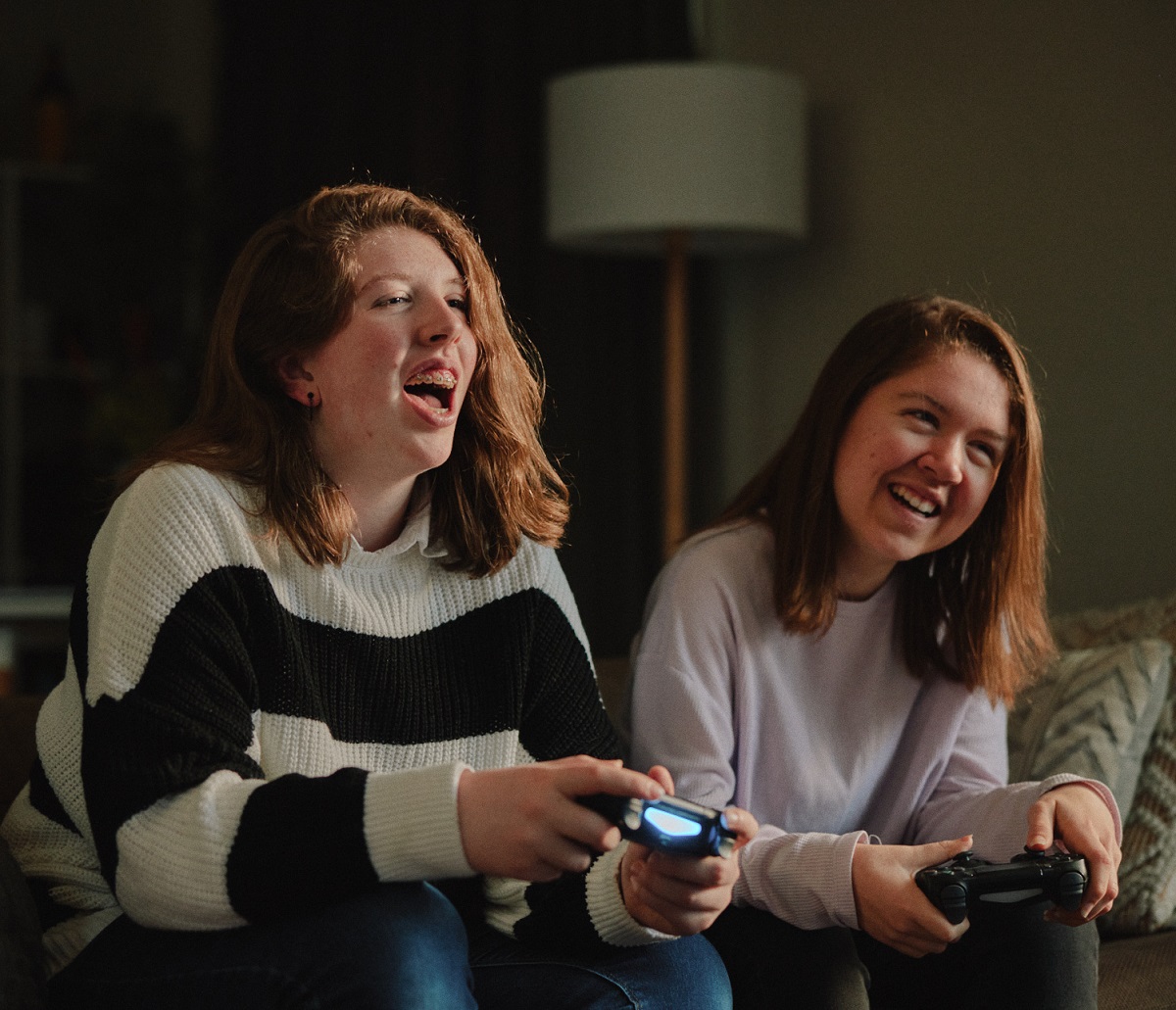 two young people sitting on a couch playing games at a Canteen cancer support community event