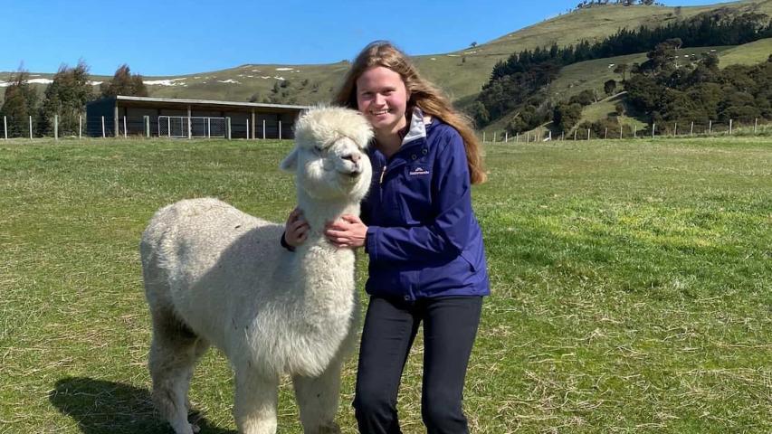 young female from the canteen hub day hugging an alpaca